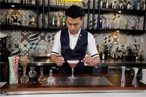 Ly Moonlight Cocktail hồng đẹp mắt đã hoàn thành với lớp bọt trứng mịn màng và trang trí quả nho tươi, vỏ cam vàng.