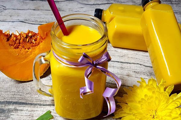 Ly sữa bí đỏ sánh mịn, màu vàng cam hấp dẫn, biểu tượng của thức uống cung cấp năng lượng và dưỡng chất