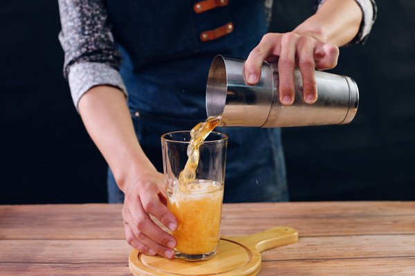 Ly trà đào cam sả pha chế, có lớp bọt mịn hấp dẫn