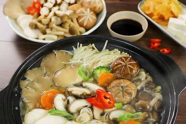 Mâm lẩu nấm chay nóng hổi, nghi ngút khói, với các loại topping đầy màu sắc đang chờ được thưởng thức