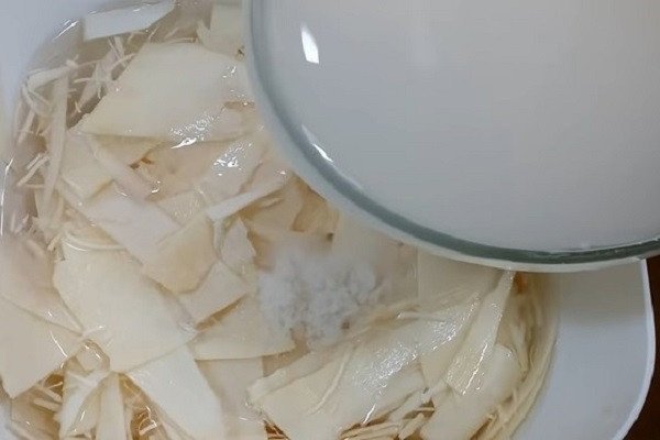 Măng ngâm trong thau nước vo gạo và muối qua đêm, giúp khử độc và làm măng chua trắng giòn
