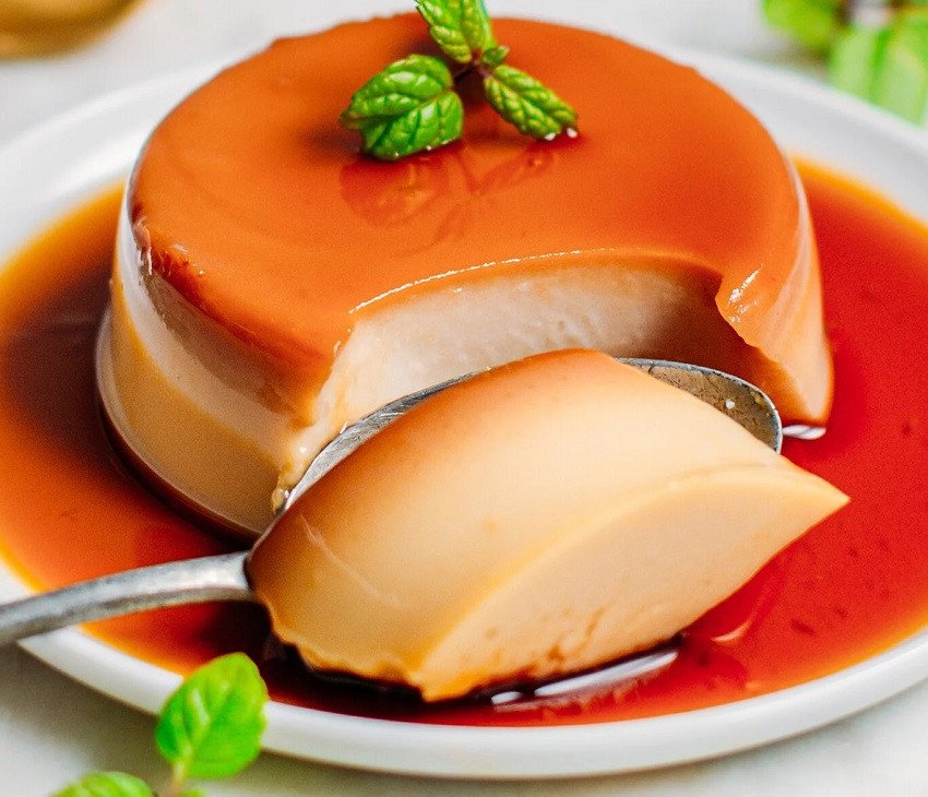Món bánh flan vàng ươm, mềm mịn được làm bằng nồi chiên không dầu đặt trên đĩa.
