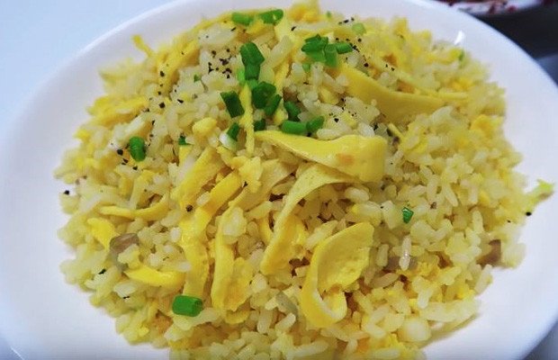 Món cơm chiên tỏi trứng vàng óng hấp dẫn được trình bày đẹp mắt trên đĩa, sẵn sàng để thưởng thức cùng tương ớt.