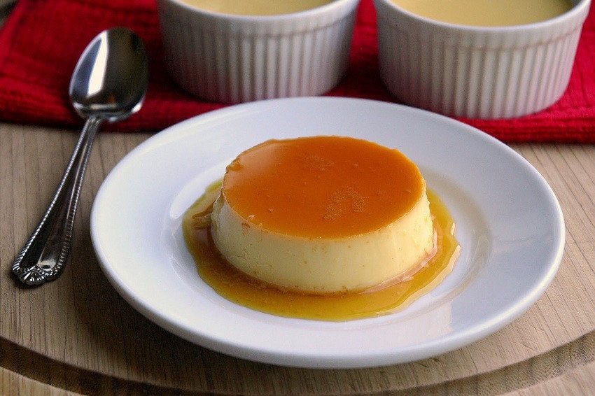 Một chiếc bánh flan thơm ngon, mềm mượt với lớp caramel óng ánh trên đĩa trắng.