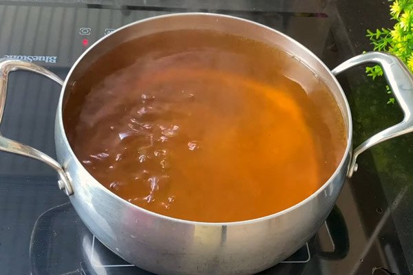 Nấu nước đường phèn sánh mịn để ngâm vải giữ độ giòn