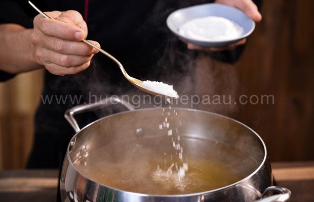 Nêm nếm gia vị vào nồi nước dùng phở đang sôi, đảm bảo hương vị hài hòa và đậm đà.