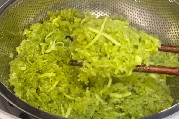 Nếp lá dứa được hấp chín dẻo trong xửng, đảm bảo độ mềm mượt cho món bánh chuối nếp nướng.