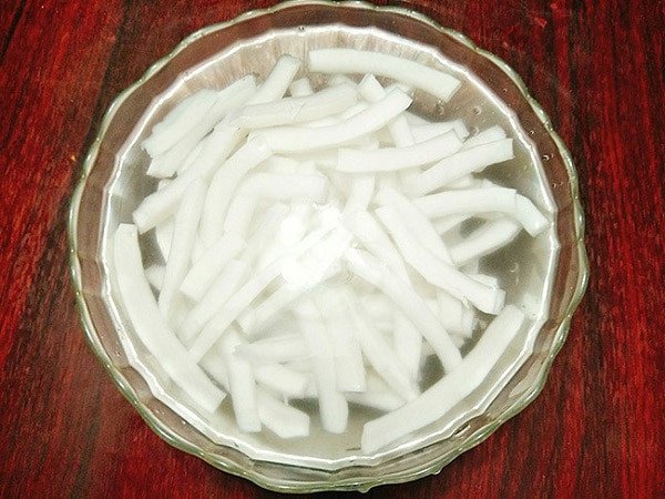 Ngâm sợi cùi dừa trong nước sạch để làm **mứt dừa** truyền thống