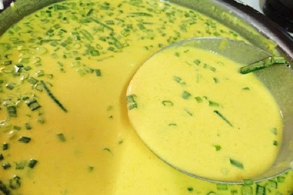 Người đầu bếp đang khuấy bột bánh xèo trong tô lớn để chuẩn bị đổ bánh xèo.
