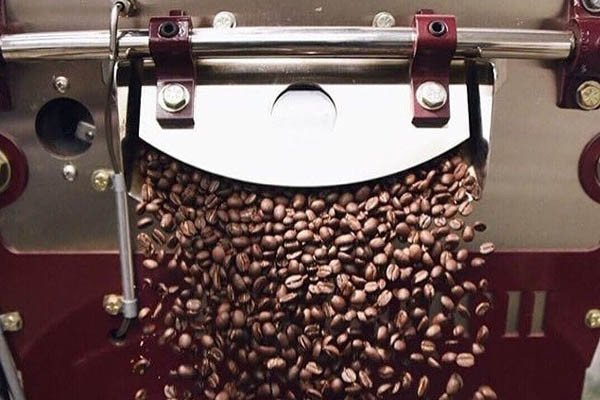 Người rang cà phê đang kiểm tra chất lượng hạt rang để đảm bảo hương vị