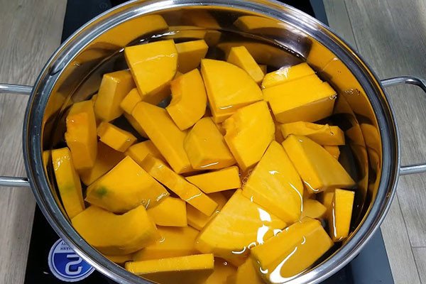 Những miếng bí đỏ được luộc chín mềm trong nồi, sẵn sàng cho công đoạn xay sữa bí đỏ