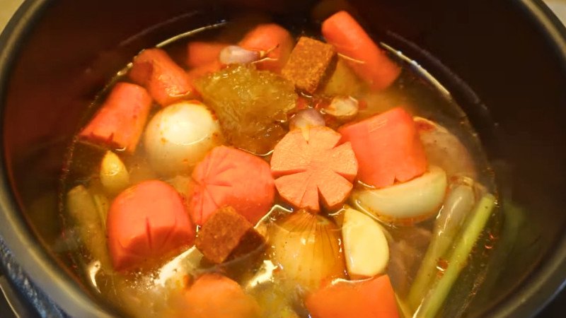 Nồi áp suất đang hầm thịt bò và rau củ, chuẩn bị cho món bò sốt vang hấp dẫn.