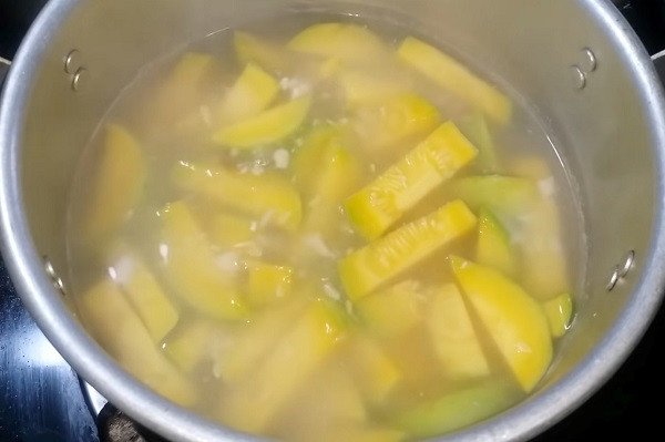 Nồi canh bí đỏ đậu phộng đang sôi nước trong, bí chín tới