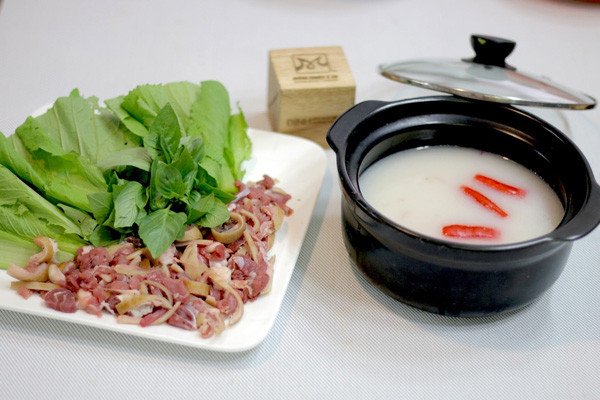 Nồi lẩu dê nhúng mẻ nóng hổi sẵn sàng để thưởng thức cùng thịt dê tươi và rau sống