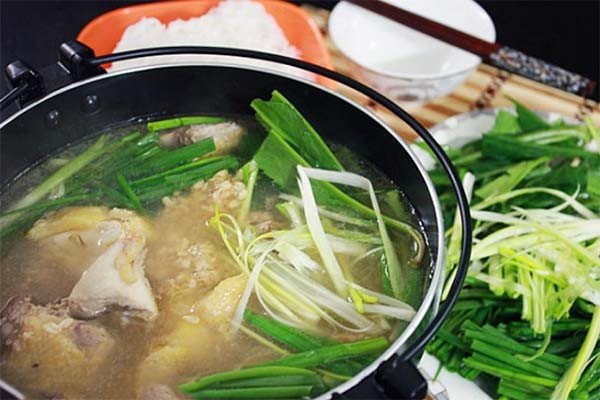 Nồi lẩu gà bỗng rượu nóng hổi, nghi ngút khói, với thịt gà mềm và các loại rau ăn kèm hấp dẫn.