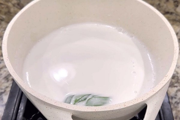 Nồi nước cốt dừa sánh mịn đang được đun nóng cho chè hạt sen đậu xanh