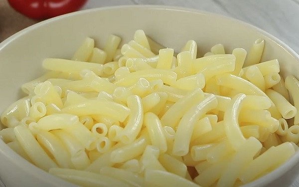 Nui ống đang được luộc chín tới, sau đó được vớt ra và trộn dầu ăn để không bị dính, chuẩn bị cho món nui xào bò thơm ngon.