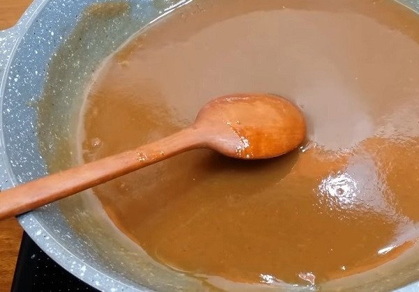Nước xốt me đang được đun sánh mịn trên bếp, nguyên liệu chính cho món bánh tráng trộn.