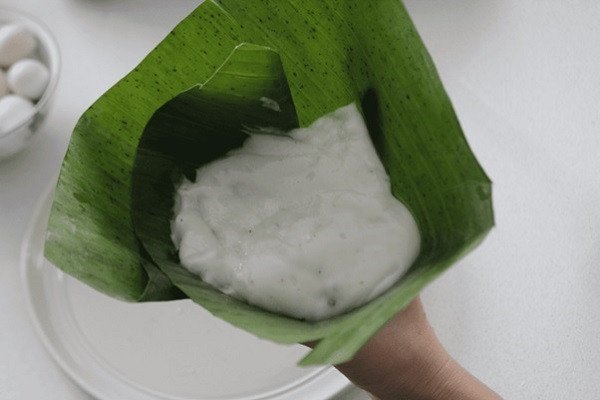 Phủ lớp bột cuối cùng lên nhân bánh giò và trứng cút