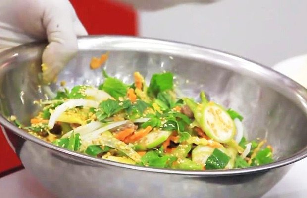 Quá trình trộn đều các nguyên liệu gỏi bò bóp thấu để ngấm gia vị