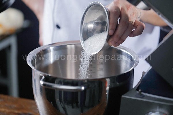 Công Thức Bánh Trứng Nướng Giòn Chuẩn Vị Tại Nhà Quy trình đổ đường vào lòng đỏ trứng gà để tạo hỗn hợp bánh trứng nướng giòn