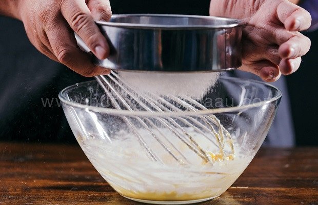 Rây bột bắp vào hỗn hợp trứng đường làm nhân bánh su kem trà xanh