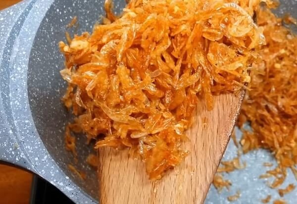 Ruốc khô được xào tơi và thơm lừng trên chảo, thành phần không thể thiếu của bánh tráng trộn.