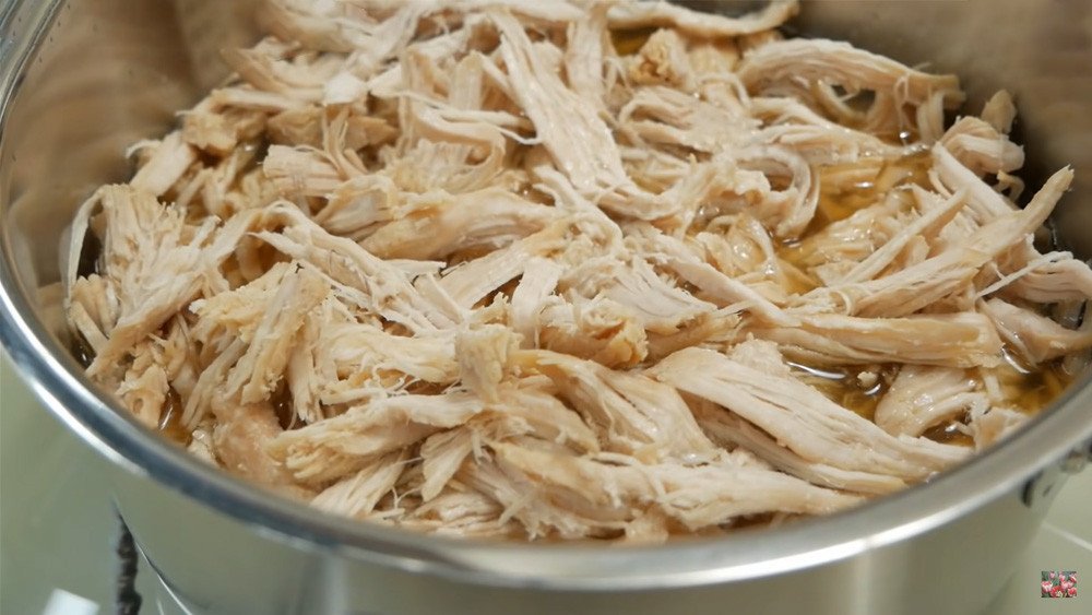 Sợi thịt heo đã luộc chín được xé tơi bằng nĩa khi còn nóng, giúp thịt dễ dàng bông ra để làm chà bông.