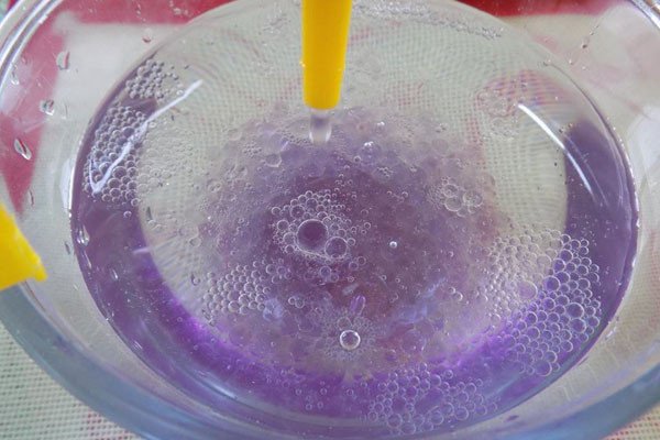 Bí Quyết Làm Thạch Thủy Tinh Trà Sữa Đơn Giản Tại Nhà Thao tác bóp từng giọt thạch thủy tinh vào nước đá để tạo hình viên thạch tròn đẹp