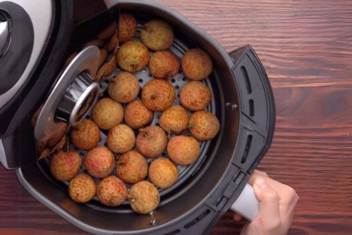 Thao tác xếp vải vào nồi chiên không dầu để sấy khô