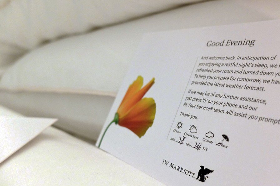 Thiệp dự báo thời tiết và socola đặt trên gối trong dịch vụ Turndown Service