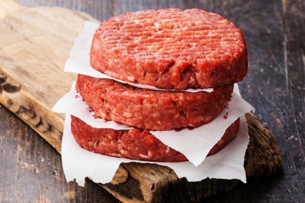 Thịt bò xay được nén chặt trong khuôn tròn làm nhân bánh mì Hamburger