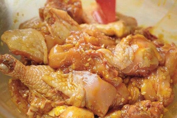 Thịt gà đang được ướp với gia vị cà ri đậm đà trước khi chế biến