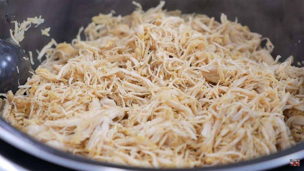 Thịt heo đã xé tơi được cho vào máy xay thịt để đánh bông thành sợi ruốc mịn màng, tơi xốp.