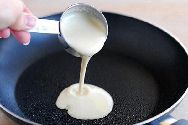 Thoa bơ lên chảo để làm bánh kếp Thái mặn không dính