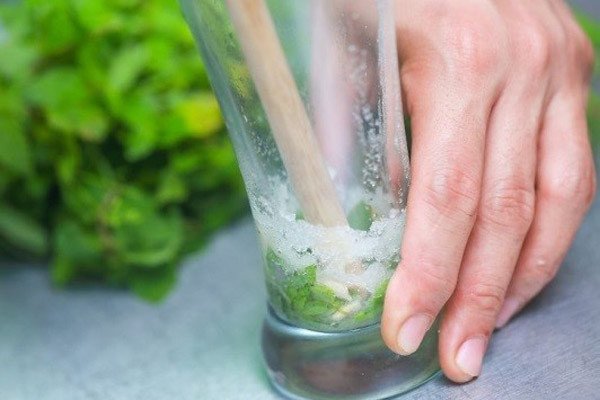Thực hiện dằm chanh và húng lủi để chiết xuất hương thơm đậm đà cho Mojito vải