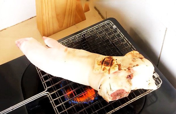 Thui chân giò heo trên bếp lửa nhỏ để loại bỏ lông và tạo mùi thơm đặc trưng