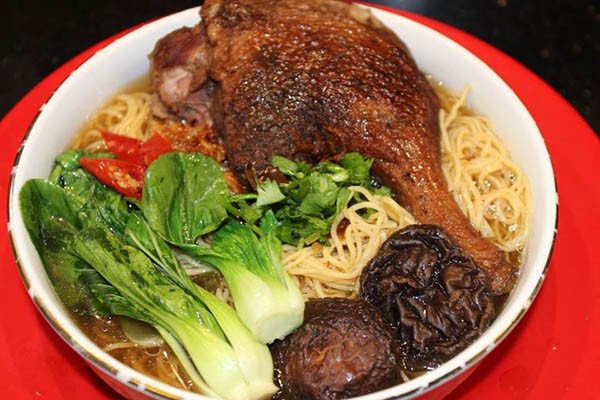 Tô mì vịt tiềm nóng hổi với sợi mì dai, thịt vịt mềm và rau cải xanh tươi, sẵn sàng để thưởng thức