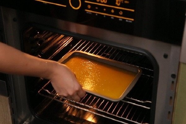 Trải đều hỗn hợp xoài lên khay nướng để làm bánh tráng xoài