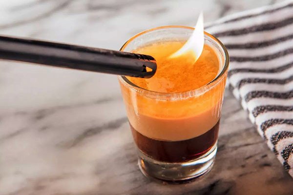 Trải nghiệm thưởng thức Cocktail B52 đang cháy, thể hiện sự mạnh mẽ và bùng nổ của hương vị thức uống B52
