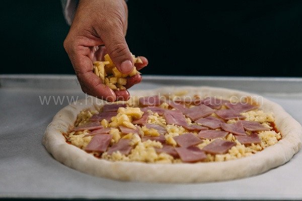 Trải nhân xúc xích và phô mai lên đế bánh Pizza