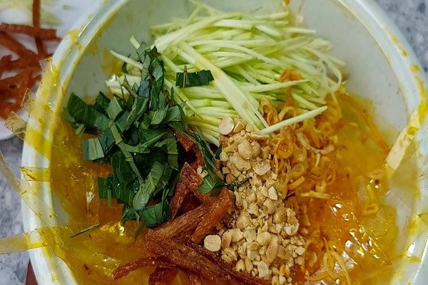 Trộn đều cho bánh tráng thấm đẫm gia vị (Ảnh: Internet)