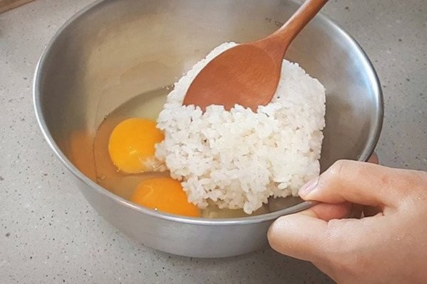 Cách Làm Cơm Chiên Hải Sản Ngon Chuẩn Vị Gia Đình Trộn đều cơm với trứng gà để cơm chiên hải sản có màu vàng đẹp mắt