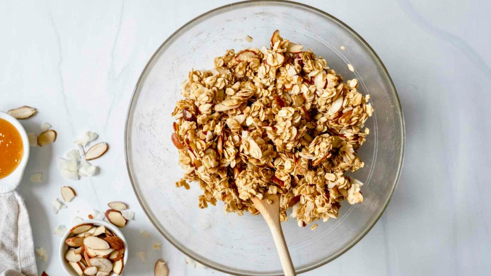 Trộn đều hỗn hợp yến mạch, hạt và mật ong để làm granola dinh dưỡng