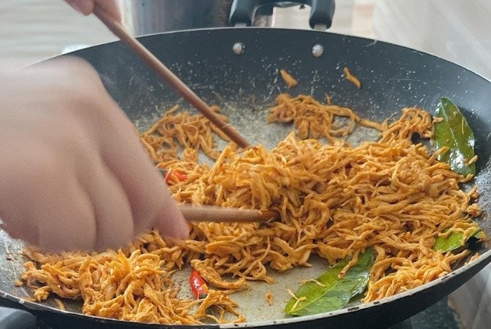 Trộn đều thịt gà xé sợi cùng sốt trên bếp với lửa nhỏ để ngấm vị