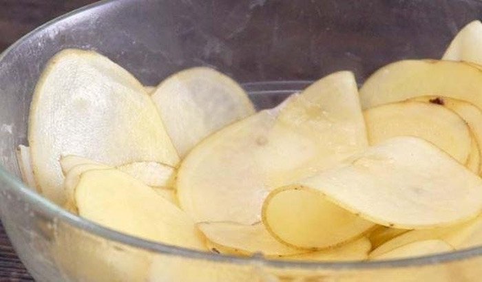 Trộn khoai tây với dầu ăn trước khi làm snack bằng nồi chiên không dầu