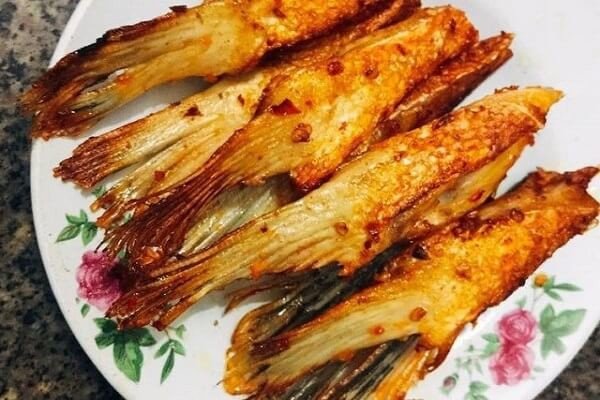 Vây cá hồi chiên nước mắm giòn tan, phủ sốt bóng bẩy và rau thơm