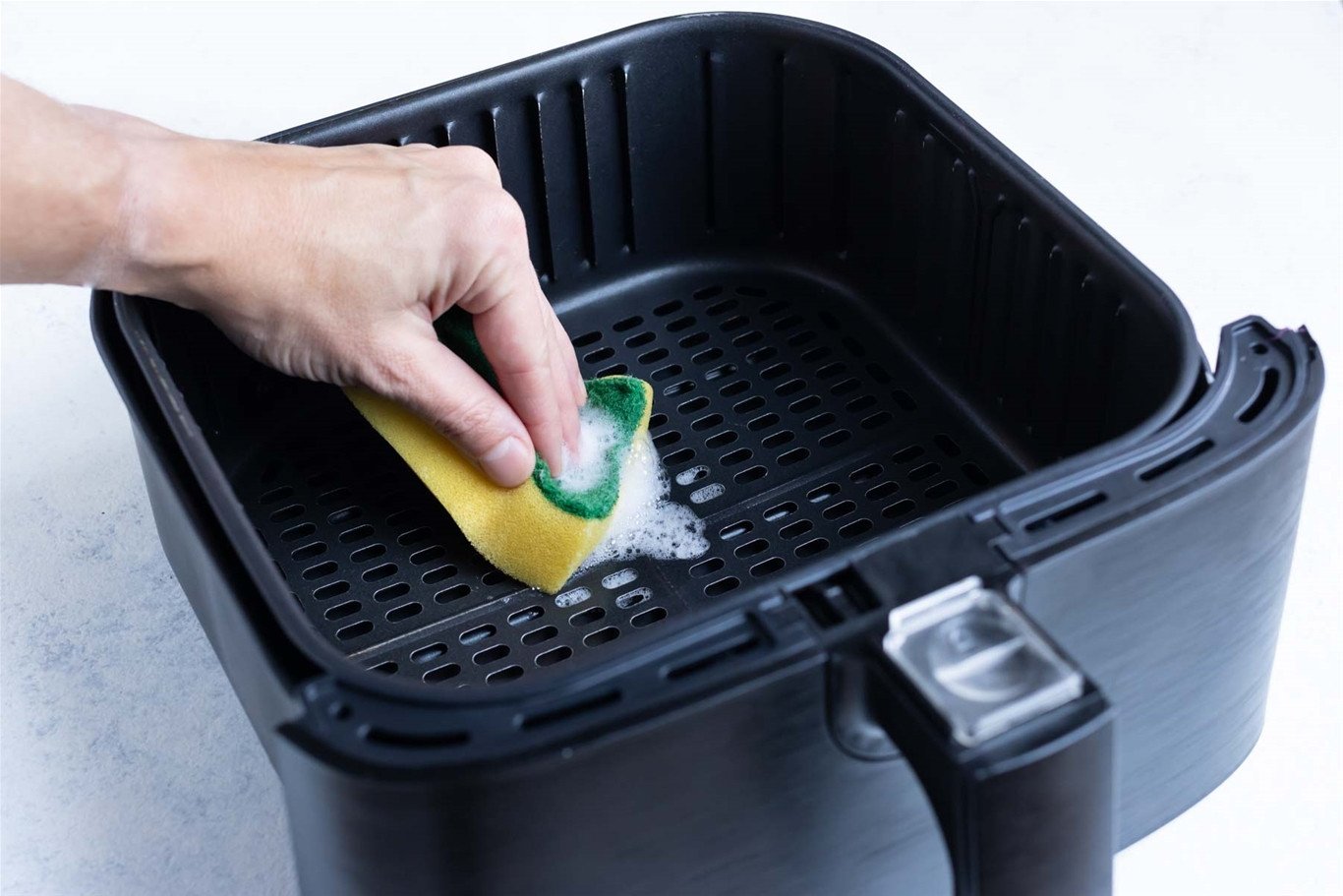 Vệ sinh khay chiên nồi không dầu bằng xà phòng nhẹ và khăn mềm