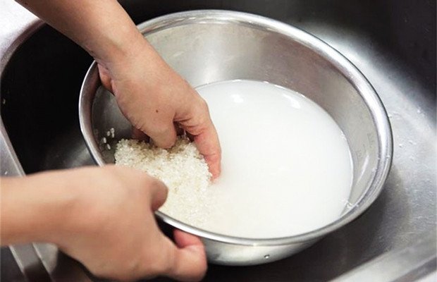 Vo sạch gạo tấm trong thau trước khi nấu cơm để đảm bảo vệ sinh
