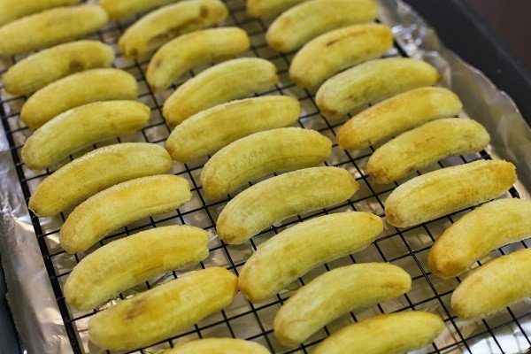 Xếp chuối tây đã nhúng chanh lên giá để chuẩn bị sấy
